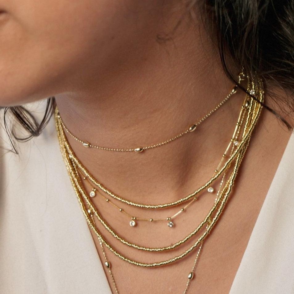 Collar mostacillas argollitas 125 cm. oro