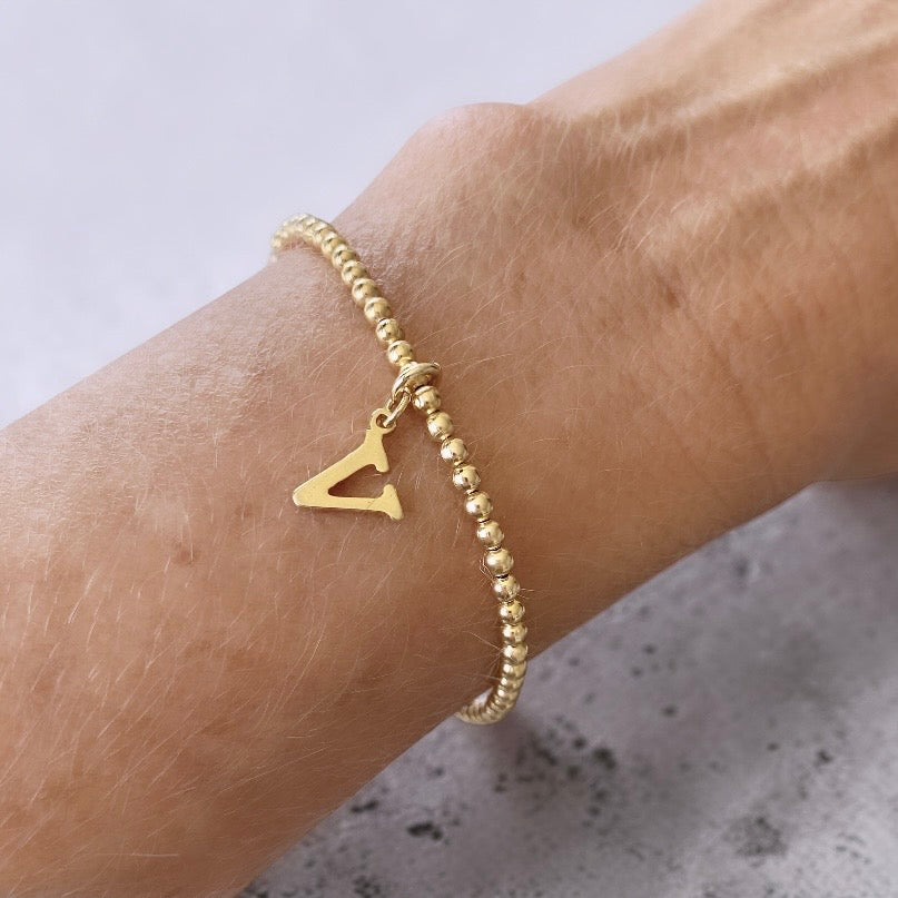 Pulsera bolitas letra oro