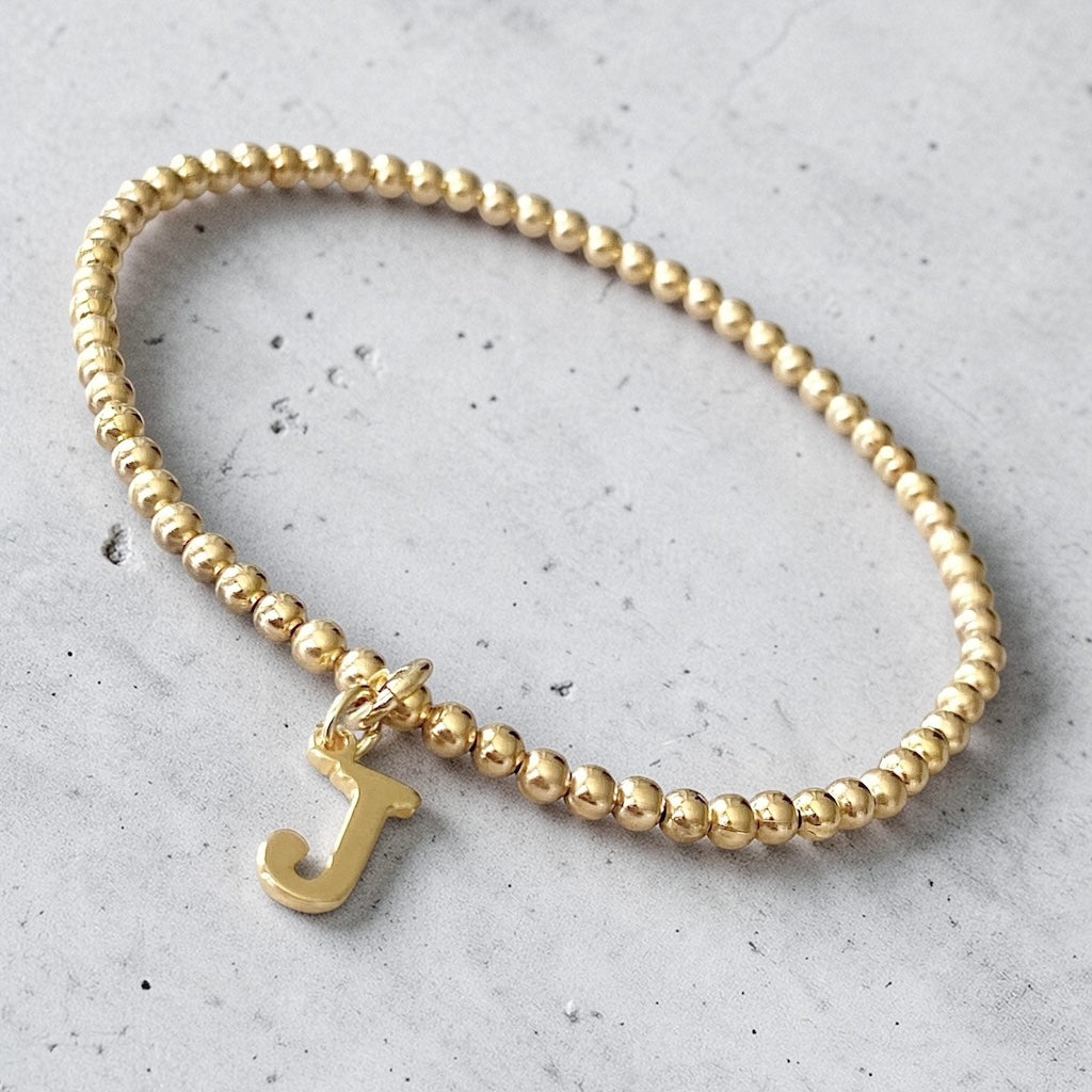 Pulsera bolitas letra oro